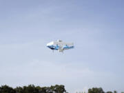 This photo provided by Amazon shows a drone delivering prescription drugs in College Station, Texas.(Amazon via AP)