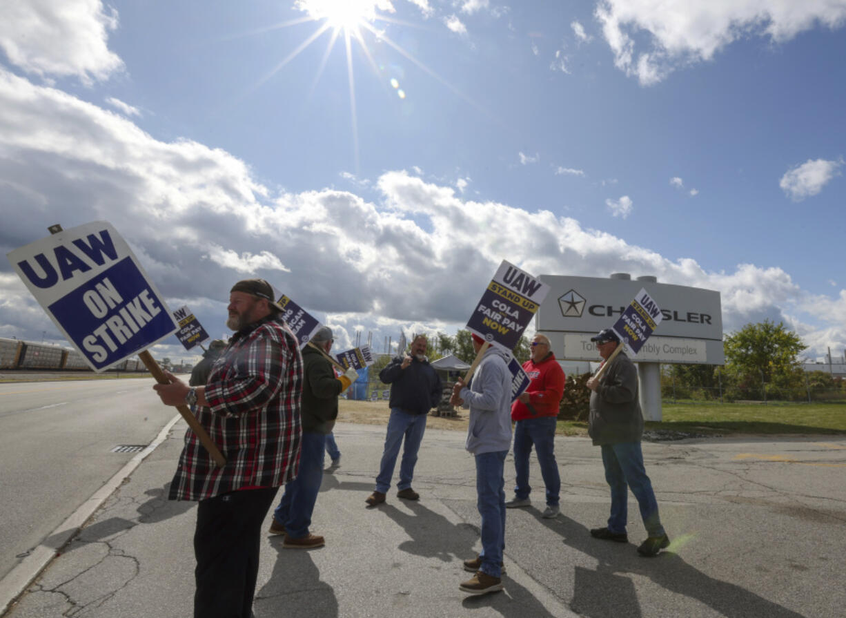 Strikers walk near the entrance of the Jeep Assembly Plant during another day of United Auto Workers strikes on Monday, Oct. 9, 2023, in Toledo, Ohio.