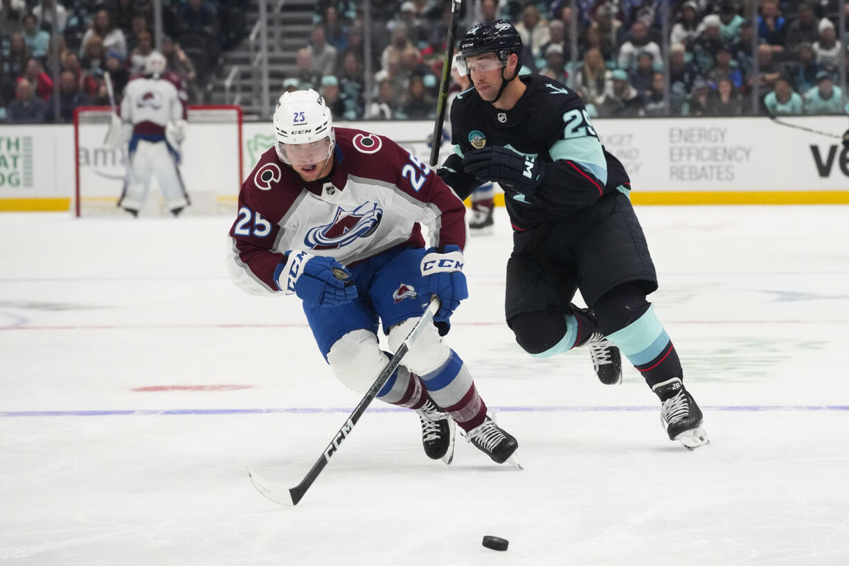 Colorado Avalanche right wing Logan O'Connor (25) breaks away from Seattle Kraken defenseman Vince Dunn (29) to gain possession before scoring during the second period of an NHL hockey game Tuesday, Oct. 17, 2023, in Seattle.