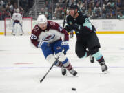 Colorado Avalanche right wing Logan O'Connor (25) breaks away from Seattle Kraken defenseman Vince Dunn (29) to gain possession before scoring during the second period of an NHL hockey game Tuesday, Oct. 17, 2023, in Seattle.