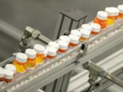 FILE- Bottles of medicine ride on a belt at a mail-in pharmacy warehouse in Florence, N.J., July 10, 2018. The Biden administration says the manufacturers of all of the first 10 prescription drugs it selected for Medicare's first price negotiations have agreed to participate. Tuesday's announcement clears the way for talks that could lower their costs in coming years and gives the White House a potential political win heading into next year's presidential election.