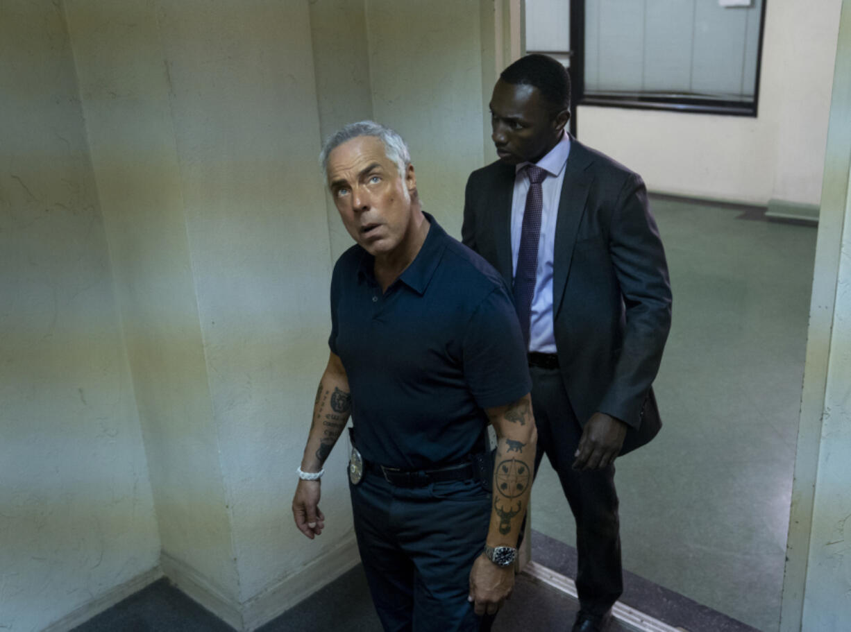 This image released by Amazon shows Titus Welliver, left, and Jamie Hector in a scene from the series "Bosch," based on the book series by Michael Connelly.