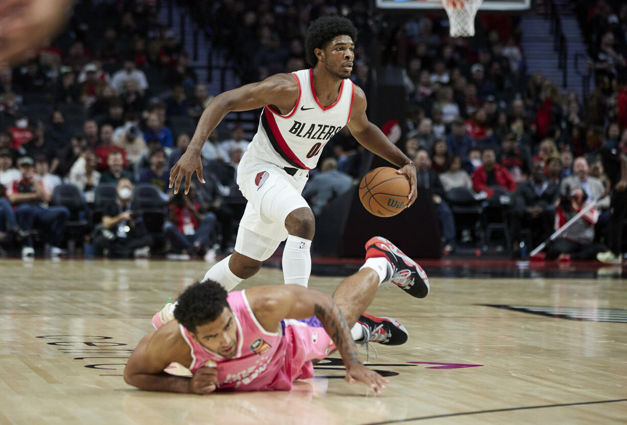 Portland Trail Blazers guard Scoot Henderson dribbles the ball past New Zealand Breakers forward Anthony Lamb during the second half of an NBA preseason basketball game in Portland, Ore., Tuesday, Oct. 10, 2023.