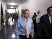 Rep. Jim Jordan, R-Ohio, center, chairman of the House Judiciary Committee and a staunch ally of former President Donald Trump, arrives as House Republicans meet again behind closed doors to work on a path to elect a new speaker after House Majority Leader Steve Scalise, R-La., dropped out of the race Thursday night, sending the GOP into further disarray, at the Capitol in Washington, Friday, Oct. 13, 2023. He is joined at right by Rep. Russ Fulcher, R-Idaho. (AP Photo/J.