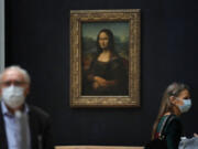 Journalists walk past Leonardo da Vinci's Mona Lisa during a visit of the Louvre museum Tuesday.