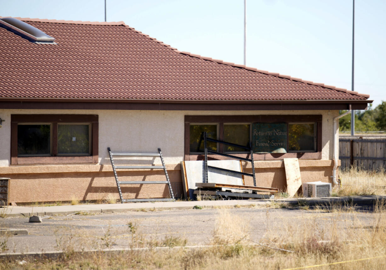 A sign covers the broken back window of the Return to Nature Funeral Home in Penrose, Colo., Monday, Oct. 16, 2023. The remains of at least 189 decaying bodies were found and removed from the Colorado funeral home, up from about 115 reported when the bodies were discovered two weeks ago, officials said Tuesday, Oct. 17.