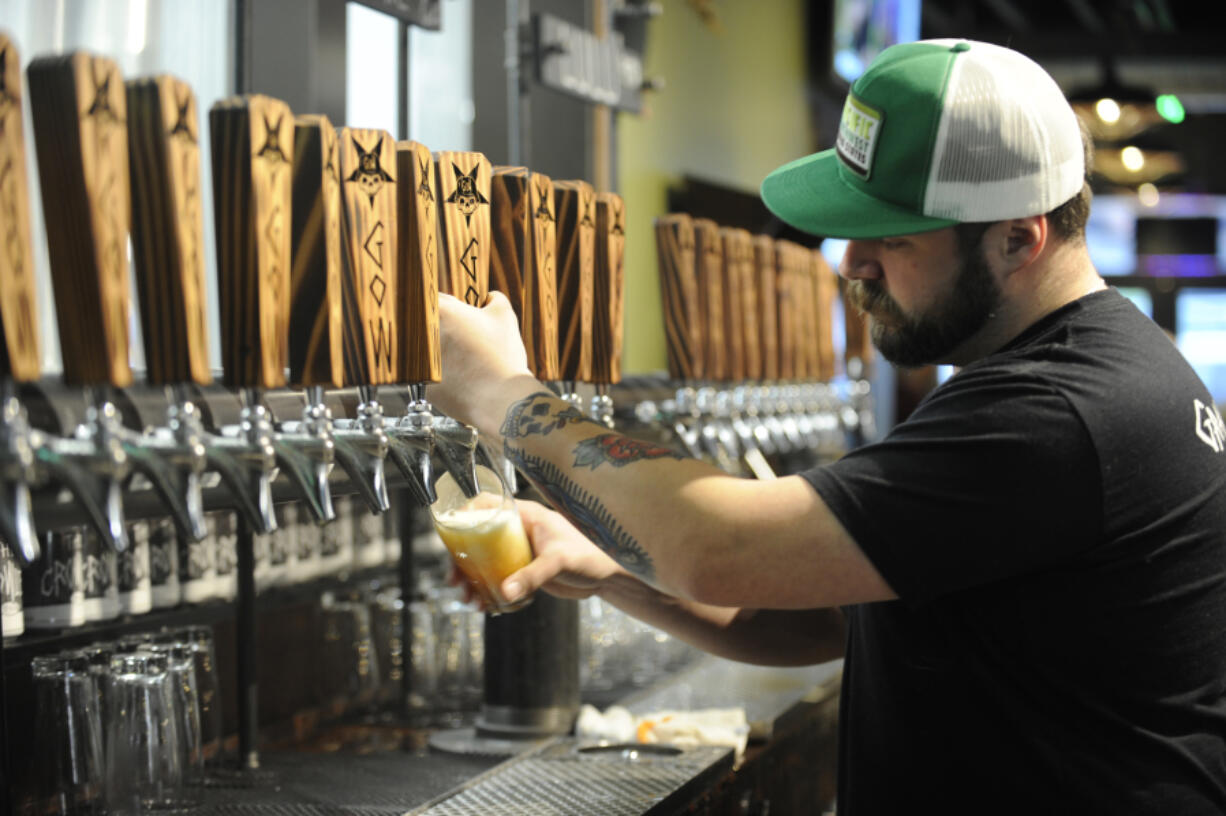 Adam Young, a bartender at Grains of Wrath Brewing, pours one of the house beers in 2018.