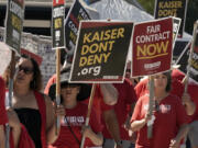 FILE - Kaiser Permanente mental health workers and supporters march outside a Kaiser facility in Sacramento, Calif., Aug. 15, 2022. Roughly 75,000 health care workers at the Kaiser Permanente hospital system are poised to go on a three-day strike at hospitals in California, Colorado, Oregon, Washington, Virginia and Washington, D.C.