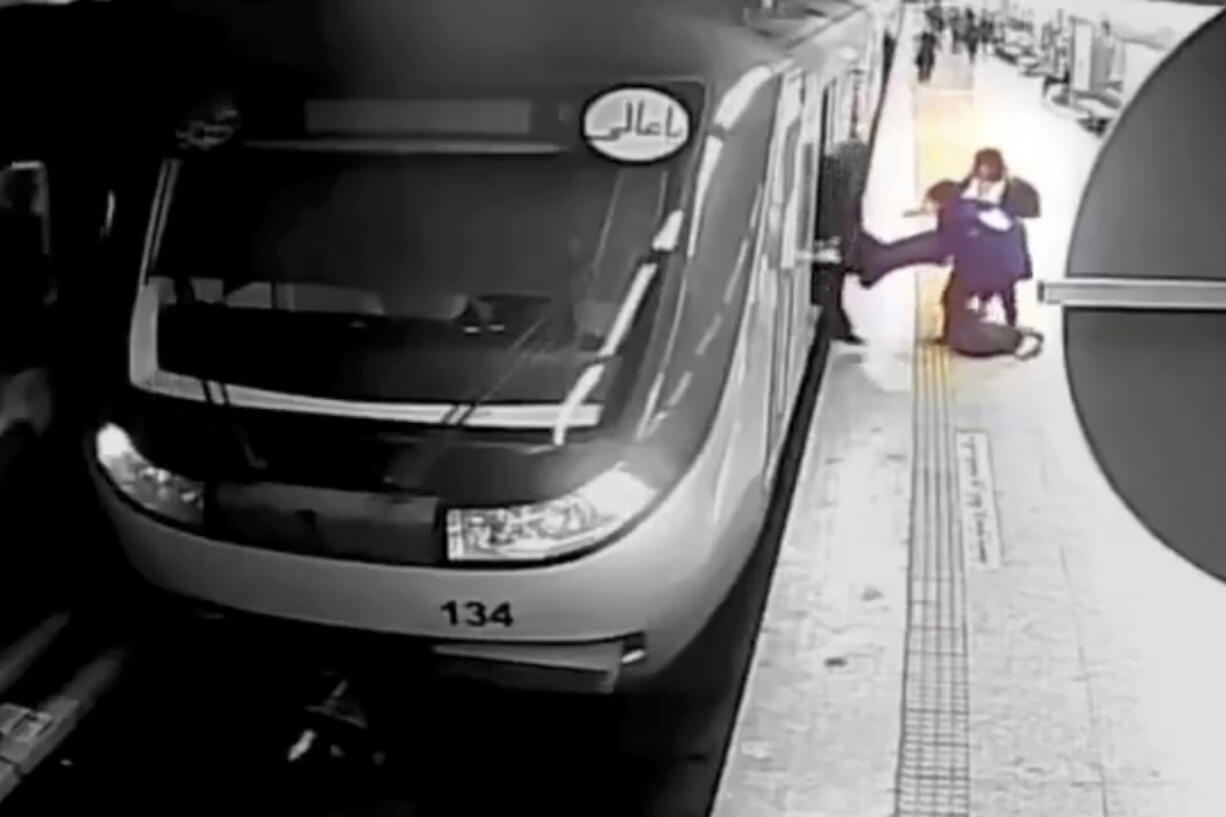 In this image from surveillance video aired by Iranian state television, women pull 16-year-old Armita Geravand from a train car on the Tehran Metro in Tehran, Iran, Sunday, Oct. 1, 2023. The mysterious injury suffered by Geravand not wearing a headscarf while boarding a Metro train in Iran's capital has reignited anger just after the one-year anniversary of the death of Mahsa Amini and the nationwide protests it sparked.