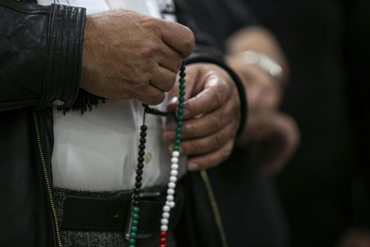 A family member of Wadea Al-Fayoume, 6, holds prayer beads at a news conference at the Muslim Community Center on Chicago's Northwest Side, Sunday, Oct. 15, 2023. Authorities say a 71-year-old Illinois man has been charged with a hate crime, accused of fatally stabbing a 6-year-old boy and seriously wounding a 32-year-old woman, in Plainfield Township, because of their Islamic faith and the Israel-Hamas war. The Council on American-Islamic Relations identified the victims as Wadea Al-Fayoume and his mother.