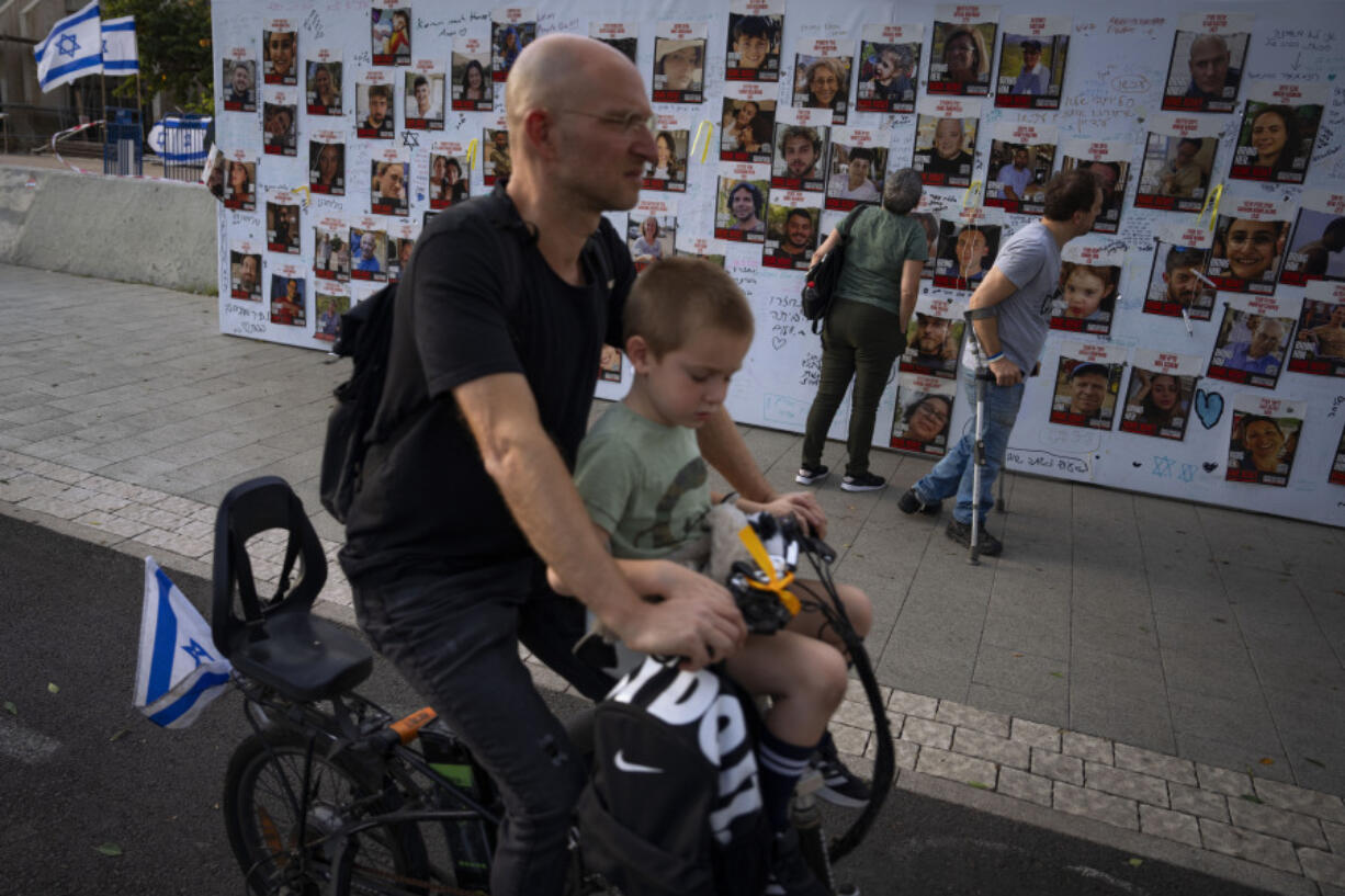 People look at photographs of hostages. mostly Israeli civilians who were abducted during the Oct. 7, unprecedented Hamas attack on Israel, in Tel Aviv, Israel Monday, Oct. 30, 2023. Just last month, Israeli Prime Minister Benjamin Netanyahu predicted a new era of peace and prosperity in the Middle East, based on growing acceptance of Israel within the region. Today, with the Israel-Hamas war in its fourth week, that vision is in tatters.