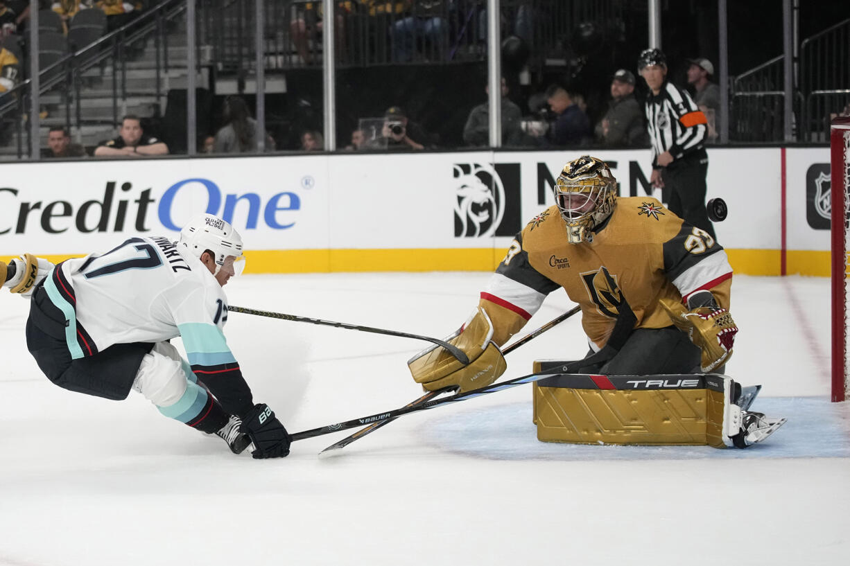 Seattle Kraken center Jaden Schwartz (17) attempts to knock the puck past Vegas Golden Knights goaltender Adin Hill (33) during the first period of an NHL hockey game Tuesday, Oct. 10, 2023, in Las Vegas.