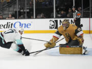 Seattle Kraken center Jaden Schwartz (17) attempts to knock the puck past Vegas Golden Knights goaltender Adin Hill (33) during the first period of an NHL hockey game Tuesday, Oct. 10, 2023, in Las Vegas.