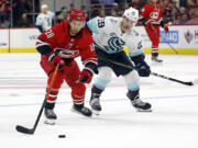 Carolina Hurricanes' Sebastian Aho (20) gathers in the puck on a breakaway as Seattle Kraken's Vince Dunn (29) gives chase during the second period of an NHL hockey game in Raleigh, N.C., Thursday, Oct. 26, 2023.