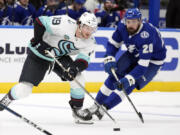 Seattle Kraken left wing Jared McCann (19) skates around Tampa Bay Lightning left wing Nicholas Paul (20) during the third period of an NHL hockey game Monday, Oct. 30, 2023, in Tampa, Fla.