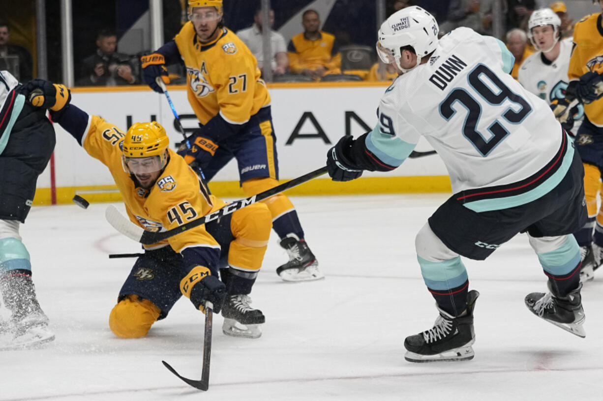 Seattle Kraken defenseman Vince Dunn (29) shoots the puck past Nashville Predators defenseman Alexandre Carrier (45) during the first period of an NHL hockey game Thursday, Oct. 12, 2023, in Nashville, Tenn.