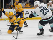 Seattle Kraken defenseman Vince Dunn (29) shoots the puck past Nashville Predators defenseman Alexandre Carrier (45) during the first period of an NHL hockey game Thursday, Oct. 12, 2023, in Nashville, Tenn.