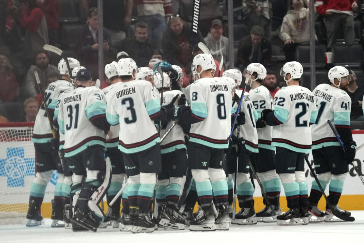 Seattle Kraken players celebrate after Jordan Eberle scored against the Detroit Red Wings during overtime of an NHL hockey game Tuesday, Oct. 24, 2023, in Detroit.