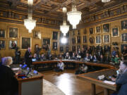 Mats Larsson, member of the Royal Academy of Sciences, standing at left, speaks during the announcement of the winner of the 2023 Nobel Prize in Physics, at the Royal Academy of Sciences, in Stockholm, Tuesday, Oct. 3, 2023. The Nobel Prize in physics has been awarded to Pierre Agostini, Ferenc Krausz and Anne L'Huillier for looking at electrons in atoms by the tiniest of split seconds.