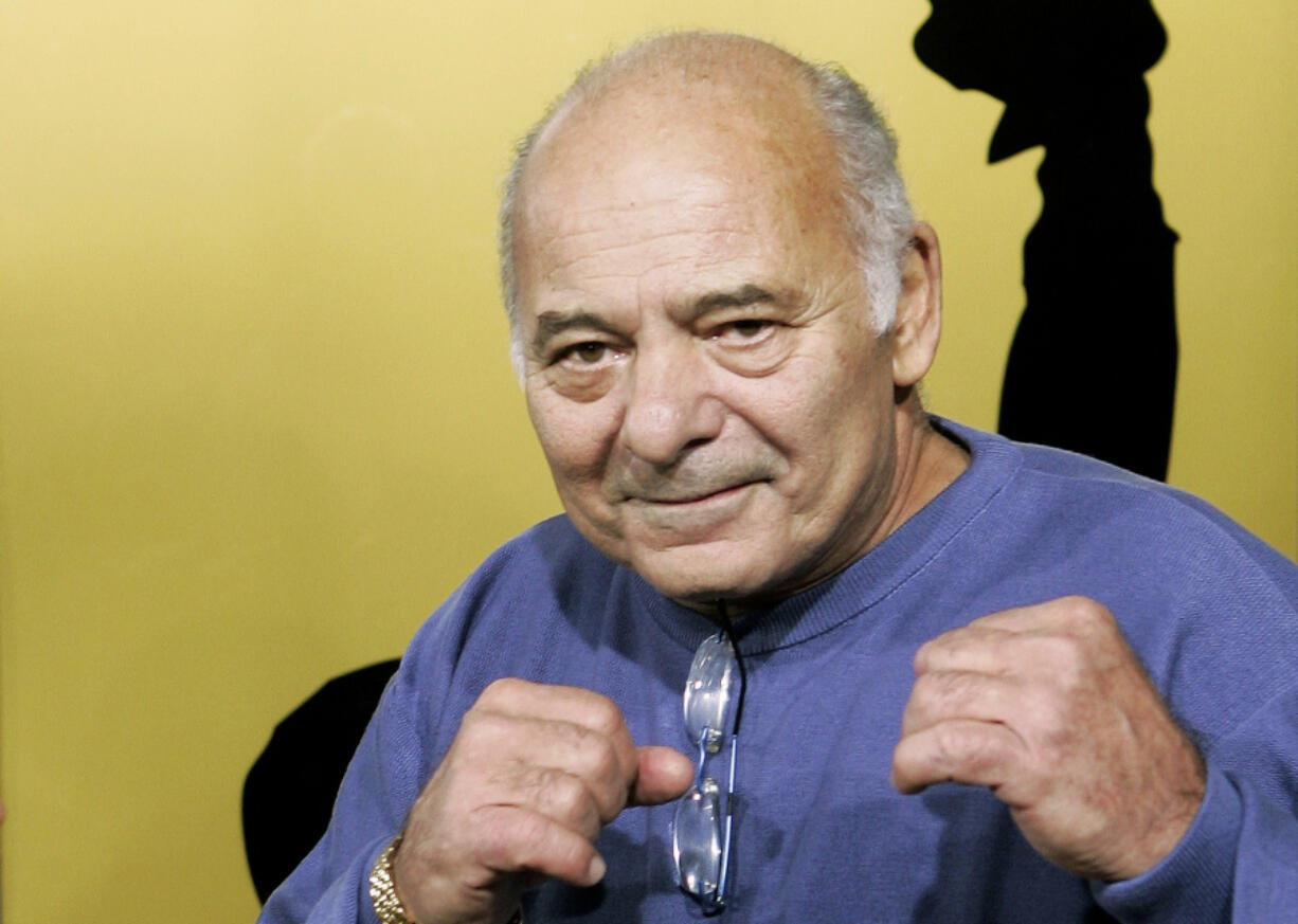 FILE - Burt Young, a cast member of the film "Rocky Balboa," gestures at the premiere of the film in Los Angeles, Dec. 13, 2006.  Burt Young, the Oscar-nominated actor who played Paulie, the rough-hewn, mumbling-and-grumbling best friend, corner-man and brother-in-law to Sylvester Stallone in the "Rocky" franchise, has died. Young died Oct. 8, 2023 in Los Angeles.