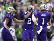 Washington wide receiver Ja'Lynn Polk (2) reacts with Will Nixon, left, after scoring a touchdown against Oregon during the first half of an NCAA college football game Saturday, Oct. 14, 2023, in Seattle.