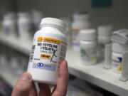 FILE - A pharmacist holds a bottle of the antibiotic doxycycline hyclate in Sacramento, Calif., July 8, 2016. The Centers for Disease Control and Prevention announced Monday, Oct. 2, 2023, that it plans to endorse the antibiotic as a post-sex morning after pill that gay and bisexual men can use to avoid some increasingly common sexually transmitted diseases.