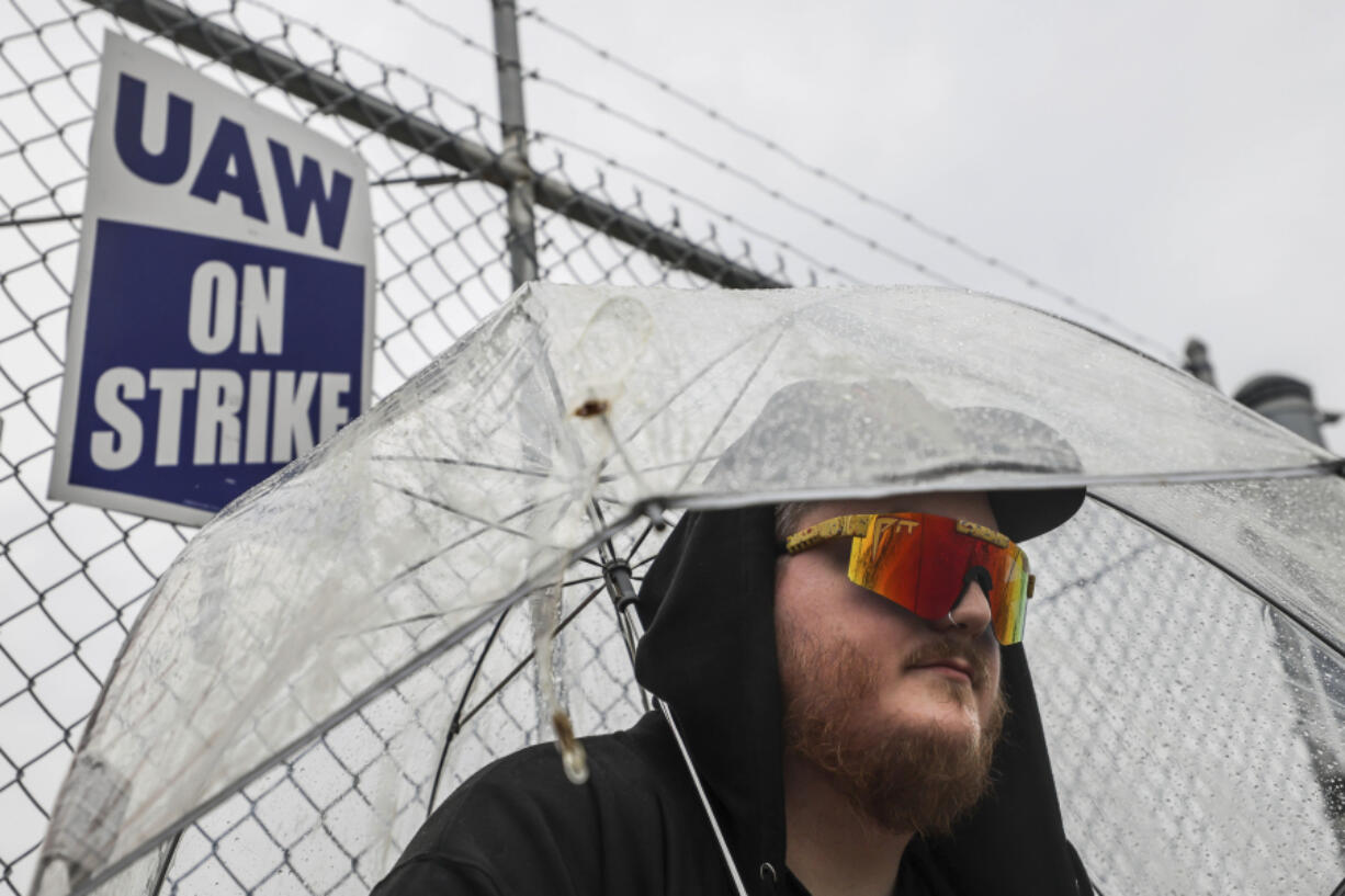 File - United Auto Workers member Matt Shanahan keeps dry while picketing outside Stellantis Toledo Assembly Complex Gate 3 on Stickney Avenue on Oct. 5, 2023 in Toledo, Ohio. From auto production lines to Hollywood, the power of labor unions is back in the national spotlight.