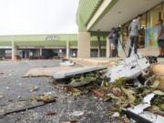 Debris remains in the parking lot outside of Bingo Time in Dunedin, Fla., on Thursday, Oct. 12, 2023. An early morning storm system that moved across parts of Florida left a path of damage to cars, houses and businesses.  (Douglas R.