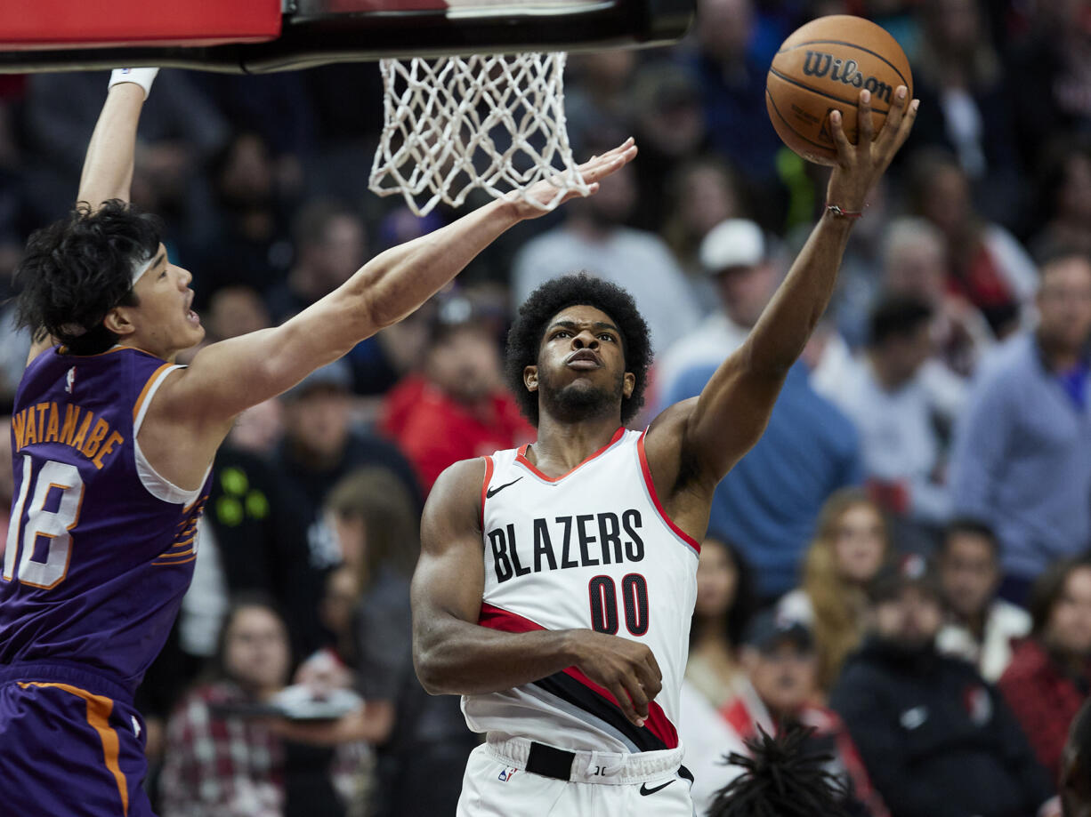 Portland Trail Blazers guard Scoot Henderson, right, shoots against Phoenix Suns forward Yuta Watanabe during the second half of an NBA preseason basketball game in Portland, Ore., Thursday, Oct. 12, 2023.