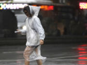 A woman walks in the rain as Typhoon Koinu approaches to Taiwan in Taipei, Taiwan, Wednesday, Oct. 4, 2023.