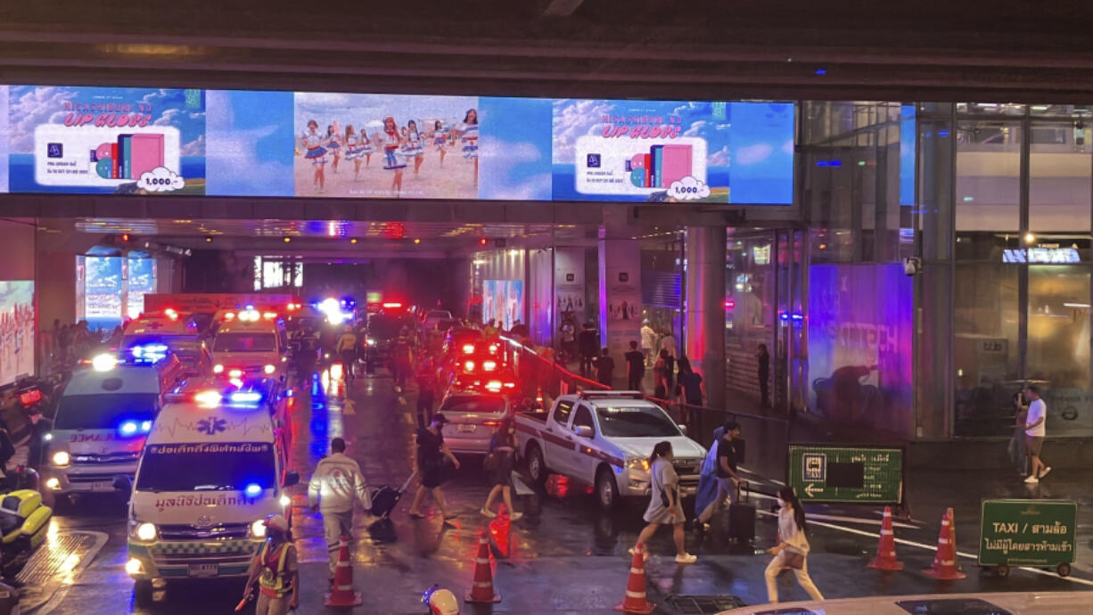 Ambulances wait outside an exit of the Siam Paragon Mall in Bangkok while shoppers rush out Tuesday, Oct. 3, 2023. Hundreds of shoppers fled the major shopping mall on Tuesday afternoon after what sounded like gunshots were heard inside. It was not immediately clear if shots had been fired, though police said there were injuries and some frightened shoppers were still hunkering down inside the mall.