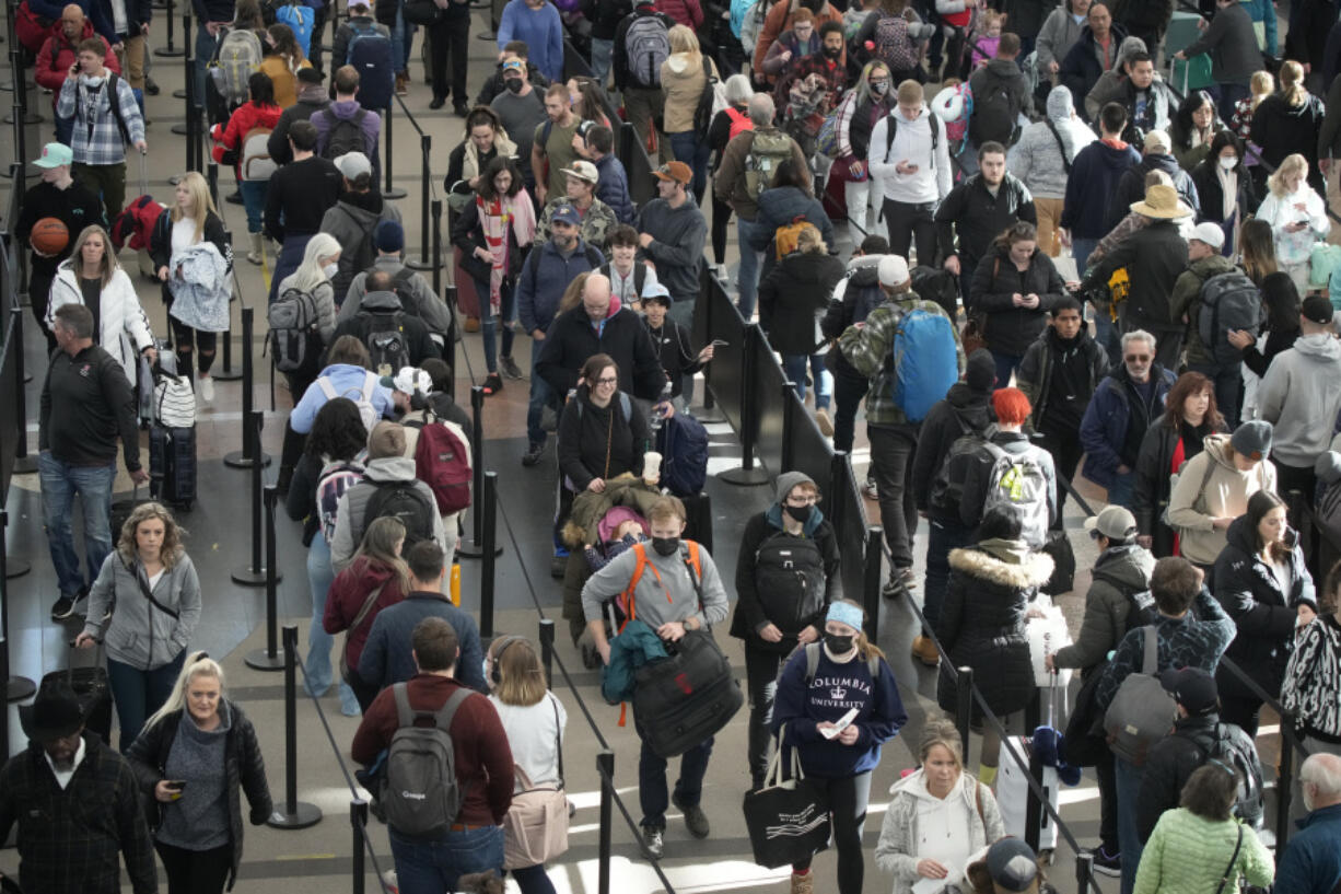 FILE - Travelers queue up to pass through the south security checkpoint in Denver International Airport on Dec. 23, 2022, in Denver. Thirty percent of Americans don't identify with a religious group -- but not all of them are atheists or agnostics. In fact, 43% of the group known as the "nones" say they believe in God, even if they largely dislike organized religion.