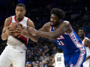 Portland Trail Blazers' Malcolm Brogdon, left, steals the ball from Philadelphia 76ers' Joel Embiid, right, during the first half of an NBA basketball game, Sunday, Oct. 29, 2023, in Philadelphia.