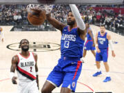 Los Angeles Clippers forward Paul George, center, dunks as Portland Trail Blazers Deandre Ayton, second from left, watches during the first half of an NBA basketball game Wednesday, Oct. 25, 2023, in Los Angeles. (AP Photo/Mark J.