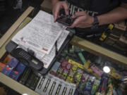 A law enforcement member of New York Sheriff's Joint Compliance Task Force makes a record of confiscated smoking products Sept. 27 during raid of an unlicensed marijuana shop in New York.