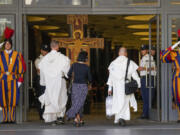 Delegates walk by the large Romanesque rood before which St. Francis of Assisi was praying when he is said to have received the commission from the Lord to rebuild the Church as they arrive for the opening session of the 16th General Assembly of the Synod of Bishops at The Vatican, Wednesday, Oct. 4, 2023. Pope Francis is convening a global gathering of bishops and laypeople to discuss the future of the Catholic Church, including some hot-button issues that have previously been considered off the table for discussion. Key agenda items include women's role in the church, welcoming LGBTQ+ Catholics, and how bishops exercise authority. For the first time, women and laypeople can vote on specific proposals alongside bishops.