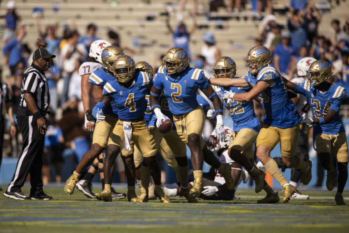 UCLA players celebrate an interception by UCLA linebacker Oluwafemi Oladejo (2) during an NCAA football game against Washington State on Saturday, Oct. 7, 2023, in Los Angeles.