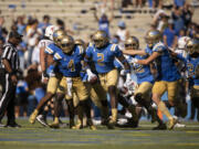 UCLA players celebrate an interception by UCLA linebacker Oluwafemi Oladejo (2) during an NCAA football game against Washington State on Saturday, Oct. 7, 2023, in Los Angeles.