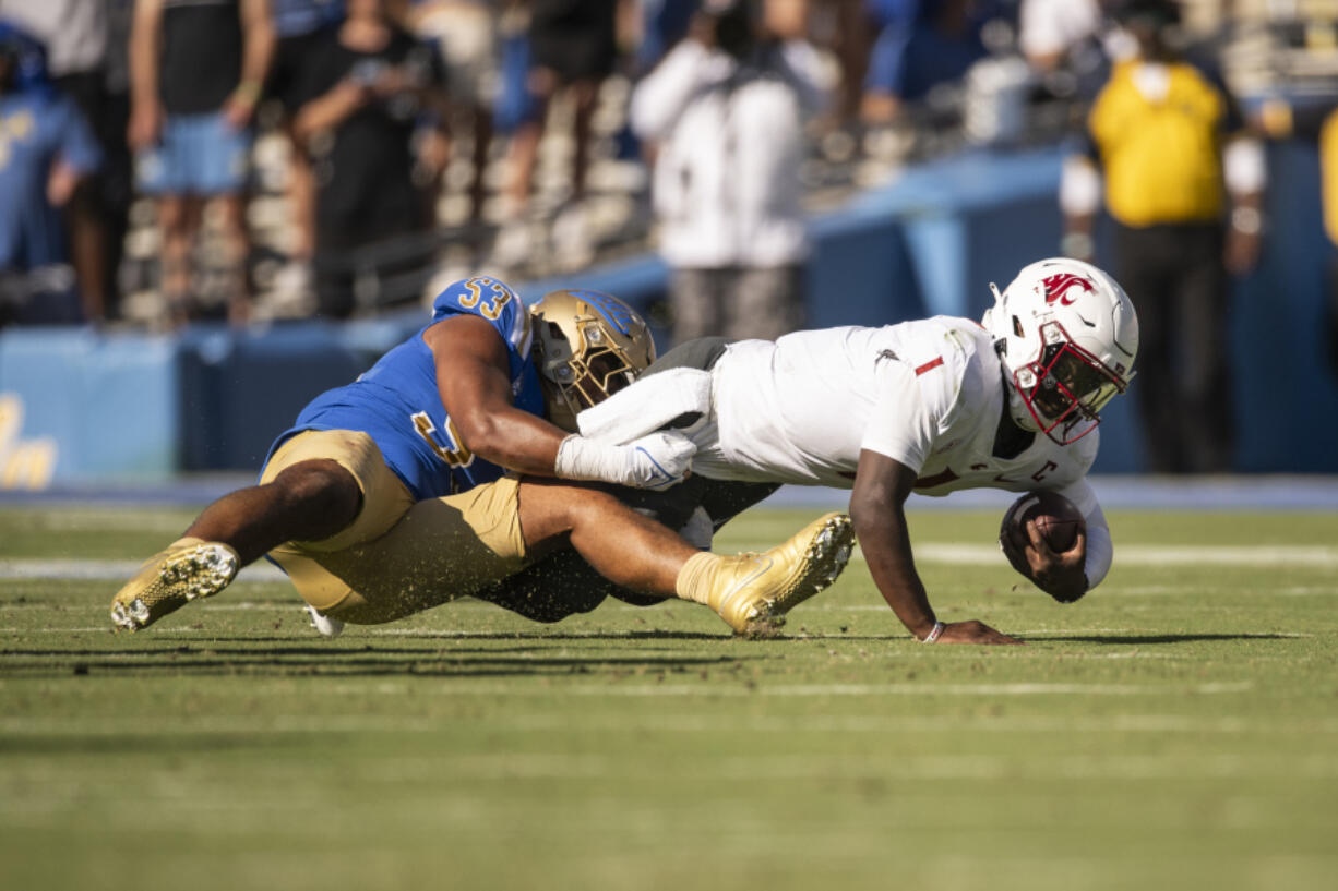 UCLA linebacker Darius Muasau (53) tackles Washington State quarterback Cameron Ward (1) for a sack during an NCAA football game on Saturday, Oct. 7, 2023, in Los Angeles.