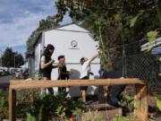 Blair Doering of Vancouver, left, lends a hand as environmental activists Becca Kempton and Monica Zazueta get a garden underway in September.