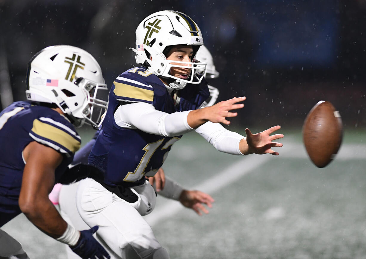 Seton Catholic sophomore Kolten Gesser, center, reaches for the snap Friday, Nov. 3, 2023, during the Cougars’ 51-7 win against Tenino at Seton Catholic High School.