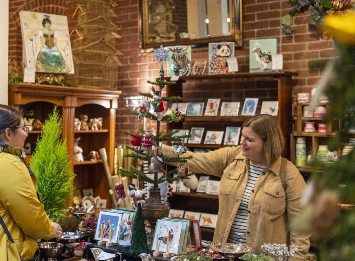 Isabella Dypold of Battle Ground, right, looks at Christmas ornaments at The French Door at Providence Academy.