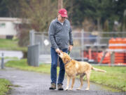 Jesse Peterson, left, walks with Charley, his 10-year-old yellow Labrador retriever, Nov. 15 in Ridgefield.