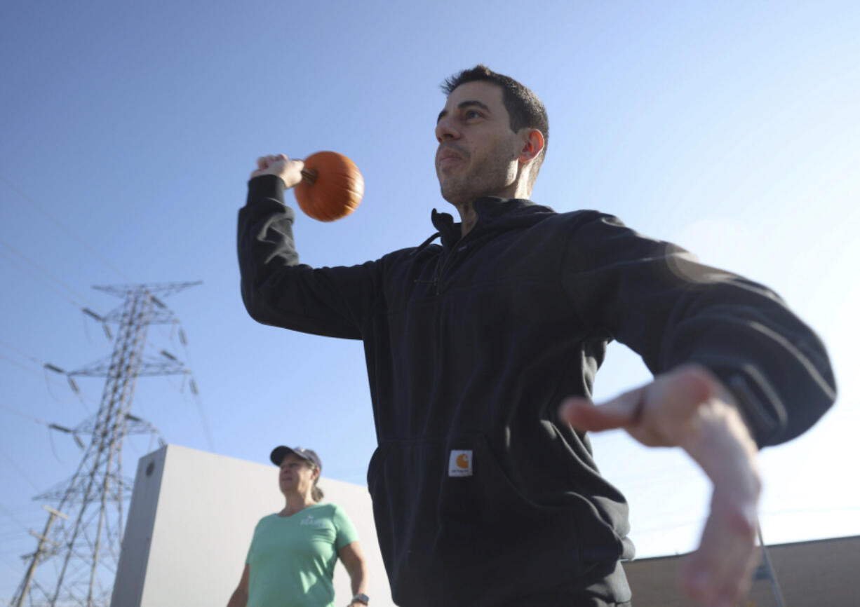 Anthony Uroni of Addison, Ill., throws a pumpkin into a dumpster Nov. 4 during a pumpkin smashing event at School &amp; Community Assistance for Recycling and Composting Education in Addison.