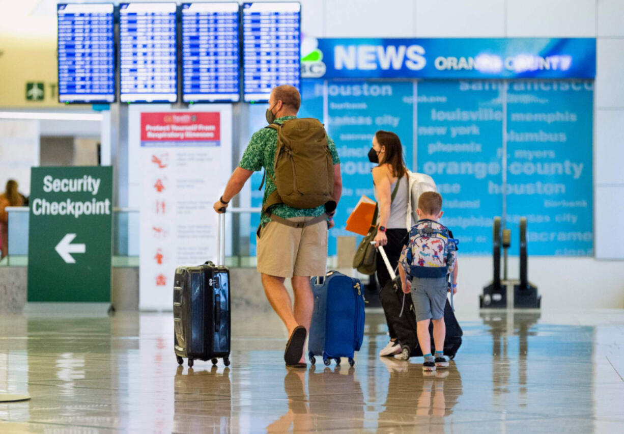 A family heads to the security check at John Wayne Airport on June 30, 2021, in Santa Ana, Calif.