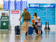 A family heads to the security check at John Wayne Airport on June 30, 2021, in Santa Ana, Calif.