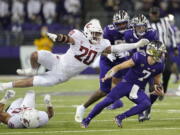 Washington State defensive end Quinn Roff (20) leaps in pursuit of Washington quarterback Sam Huard (7) during the second half of an NCAA college football game, Friday, Nov. 26, 2021, in Seattle. (AP Photo/Ted S.