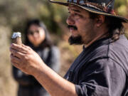 Danny Manning, a local firefighter and part of the Native American Maidu community, demonstrates Friday how his ancestors kept fires going by keeping an ember inside a piece of wood during the cultural burn.