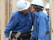 In a 2015 file photo, Jimmy Carter sneaks a kiss with Rosalynn while the couple works on a Habitat for Humanity build in Memphis.