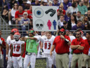 Sign held up from the sideline are used to send in plays. Or could also just be a decoy. Either way, it's becoming rather archaic system still used in college football.